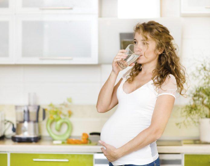 Pregnant woman drinking birch sap