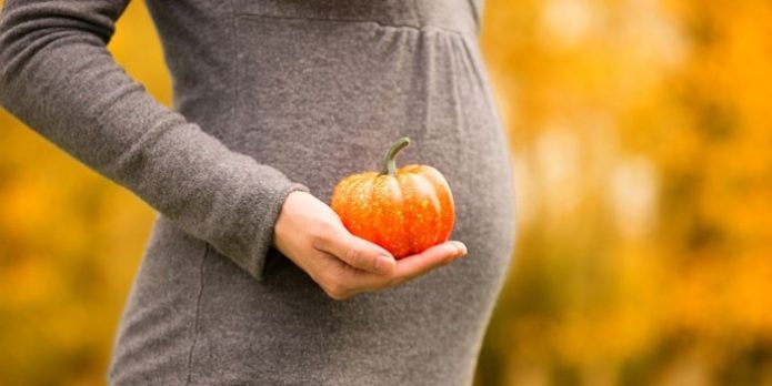 Pregnant woman with small pumpkin