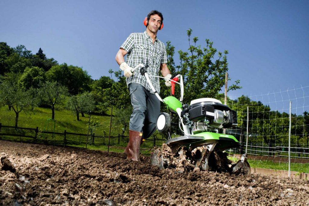 Harrowing the earth with a walk-behind tractor