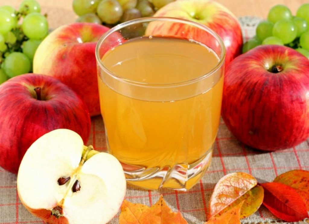 Apple juice in a glass glass and apples